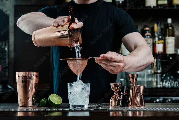 Bartender pouring cocktail into glass